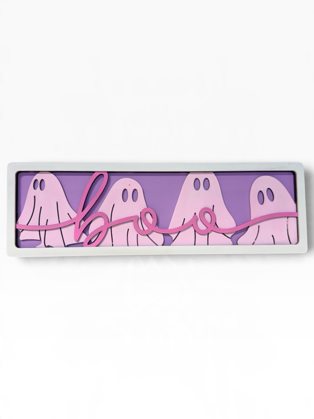 A rectangular Halloween wall sign with a white frame, featuring four light pink ghosts on a lavender-purple background with a pink cursive 'boo' script across the front.