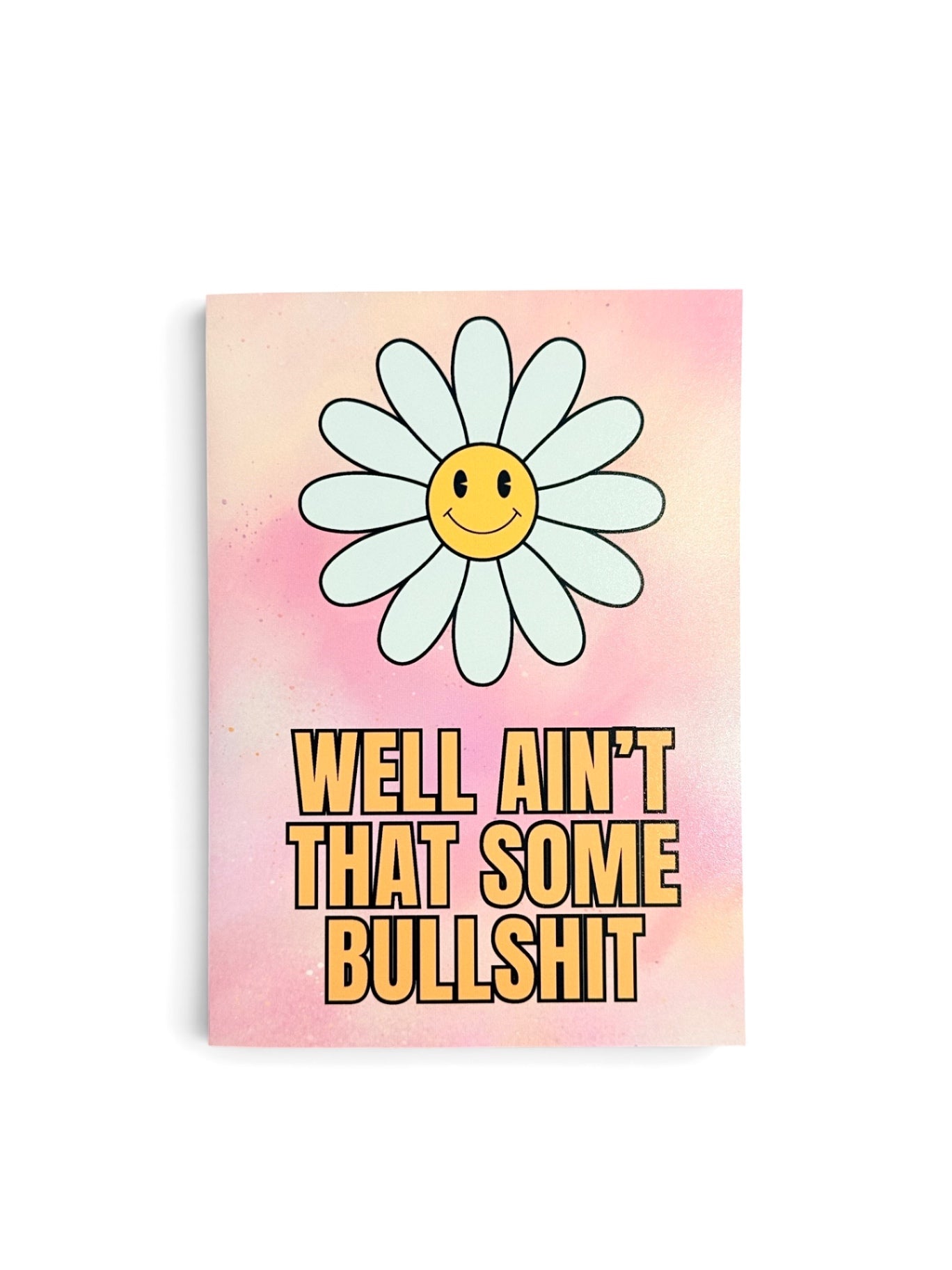 A rectangular card with a pink watercolor background, featuring a large smiling daisy flower and the text 'WELL AIN'T THAT SOME BULLSHIT' in bold yellow letters.