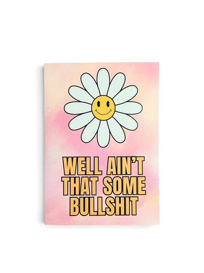 A rectangular card with a pink watercolor background, featuring a large smiling daisy flower and the text 'WELL AIN'T THAT SOME BULLSHIT' in bold yellow letters.