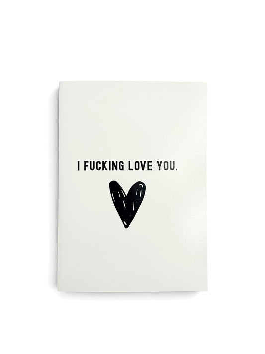A white rectangular card with the text 'I FUCKING LOVE YOU.' in black uppercase letters and a black heart graphic below, shown on a white background.