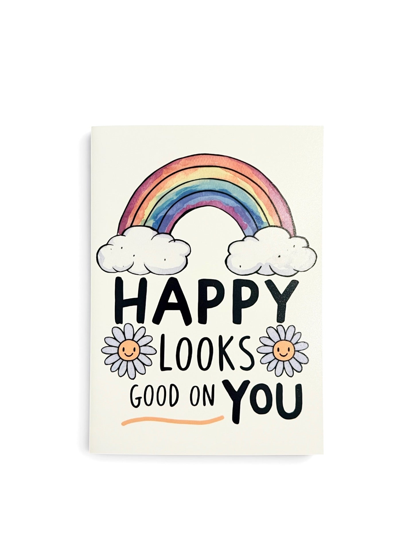 A vertical greeting card with a white background featuring a colorful rainbow, white clouds, two smiling daisies, and the text 'HAPPY LOOKS GOOD ON YOU' in black and orange lettering.