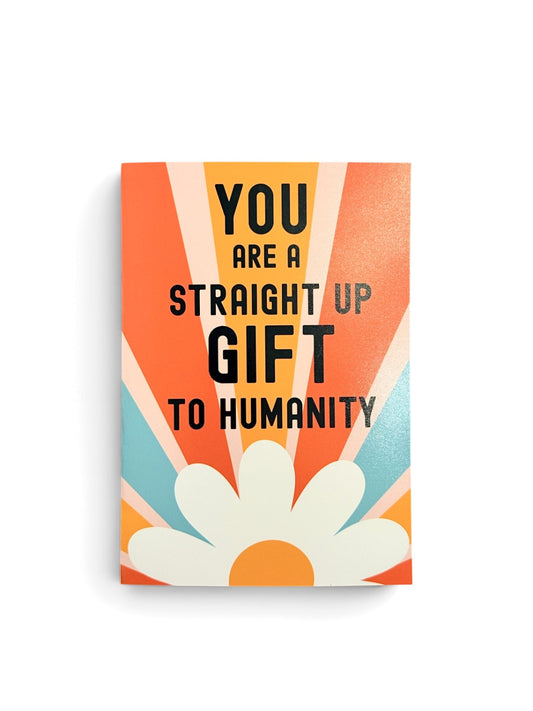 A rectangular vertical  card with retro-style text reading 'YOU ARE A STRAIGHT UP GIFT TO HUMANITY' in black over orange, peach, cream, and light blue rays, with a large white daisy flower at the bottom, shown on a white background.