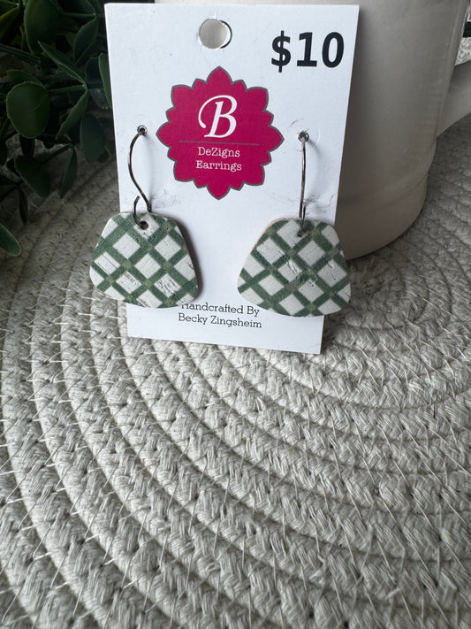 Green and white patterned geometric dangle earrings displayed on a white retail card with a pink 'B Designs Bunnings' logo, placed on a woven gray mat.