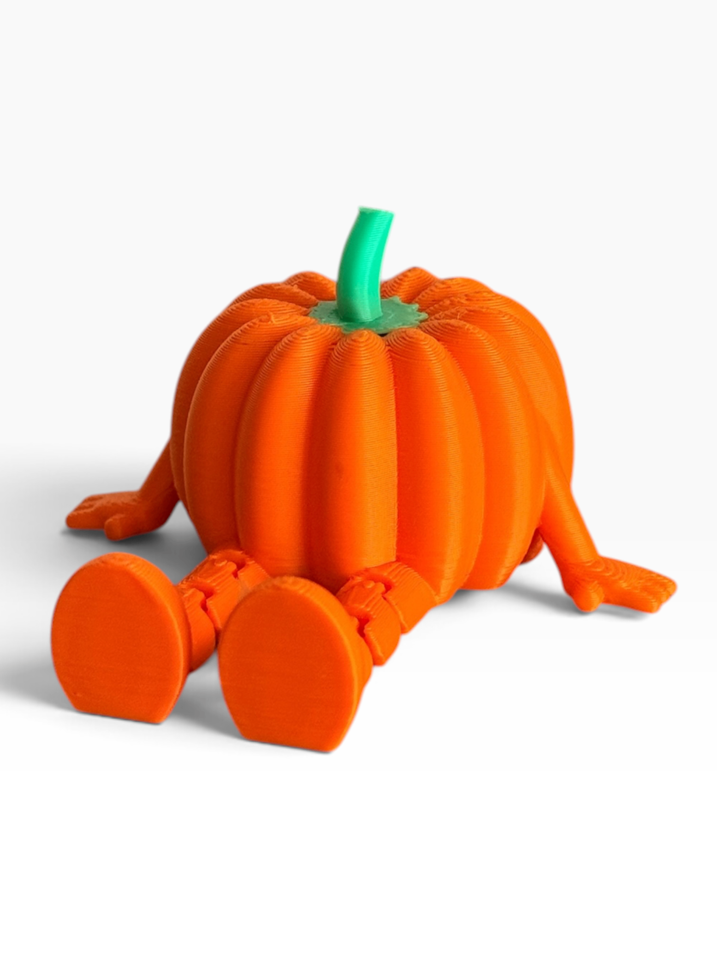 An orange 3D-printed pumpkin figurine with a green stem and articulated legs and feet, shown on a clean white background.