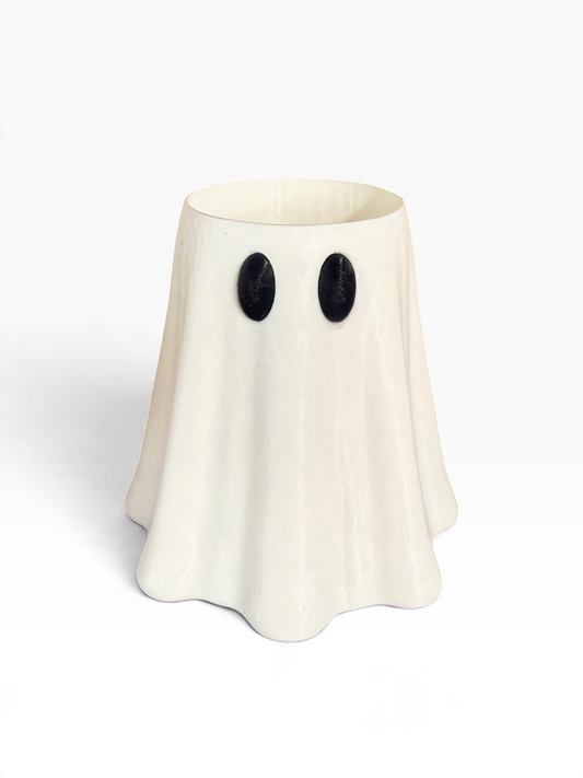 An off-white 3D printed ghost-shaped slim can holder with black oval eyes, photographed on a clean white background.