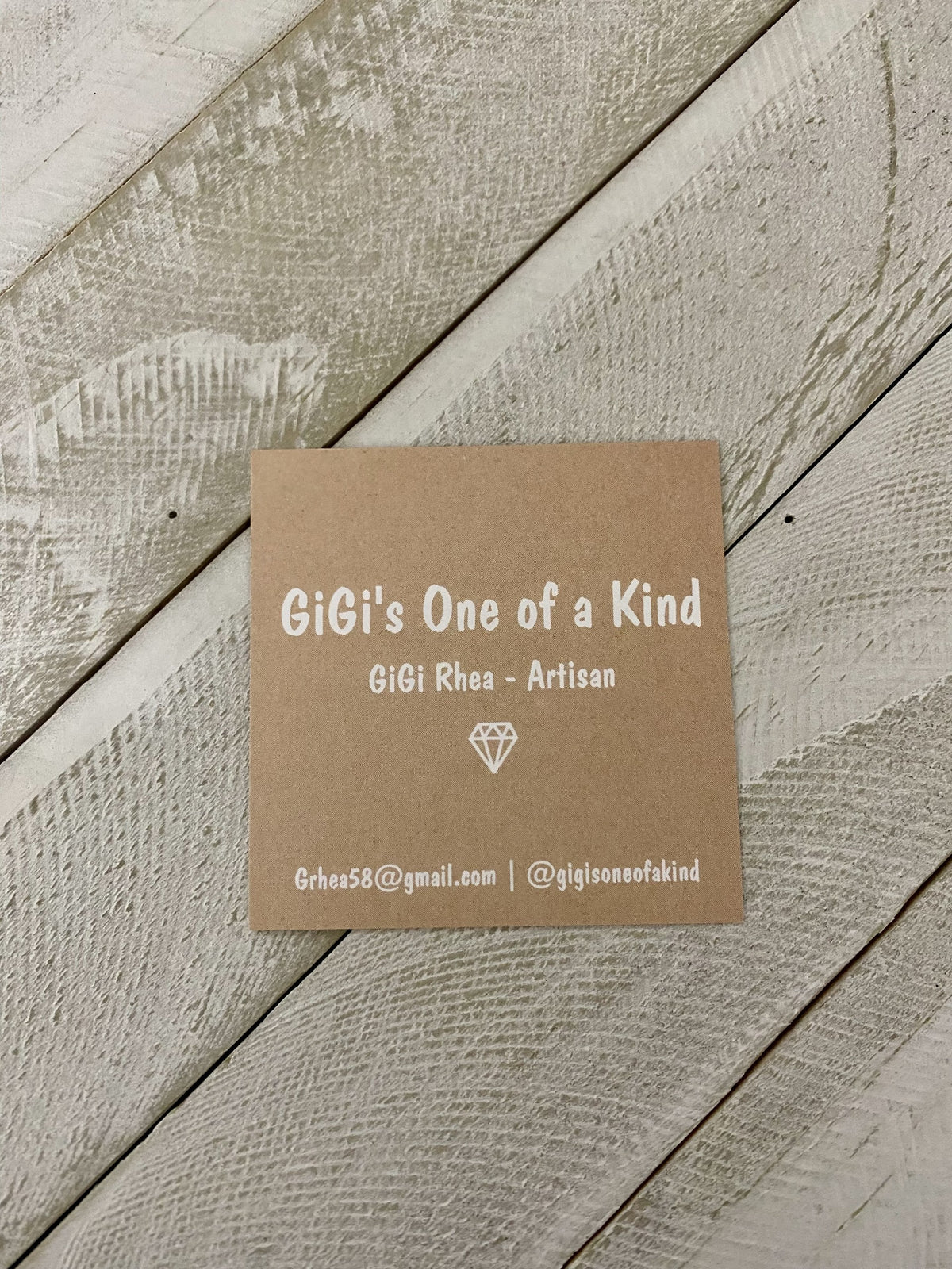 Brown square business card with white text on a wooden surface