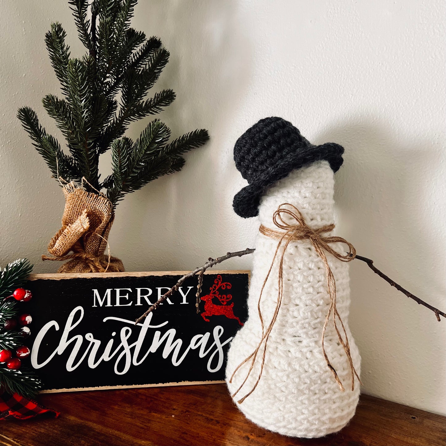 crocheted snowman on shelf with christmas decor