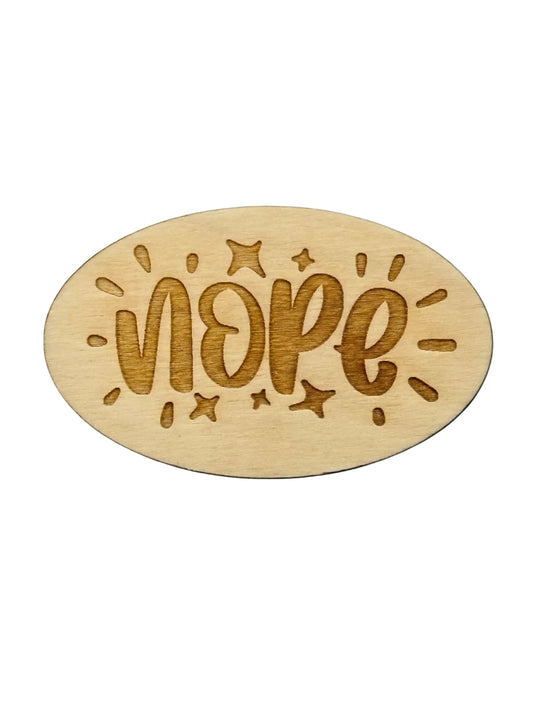 Wooden oval with 'NOPE' engraved on a black background