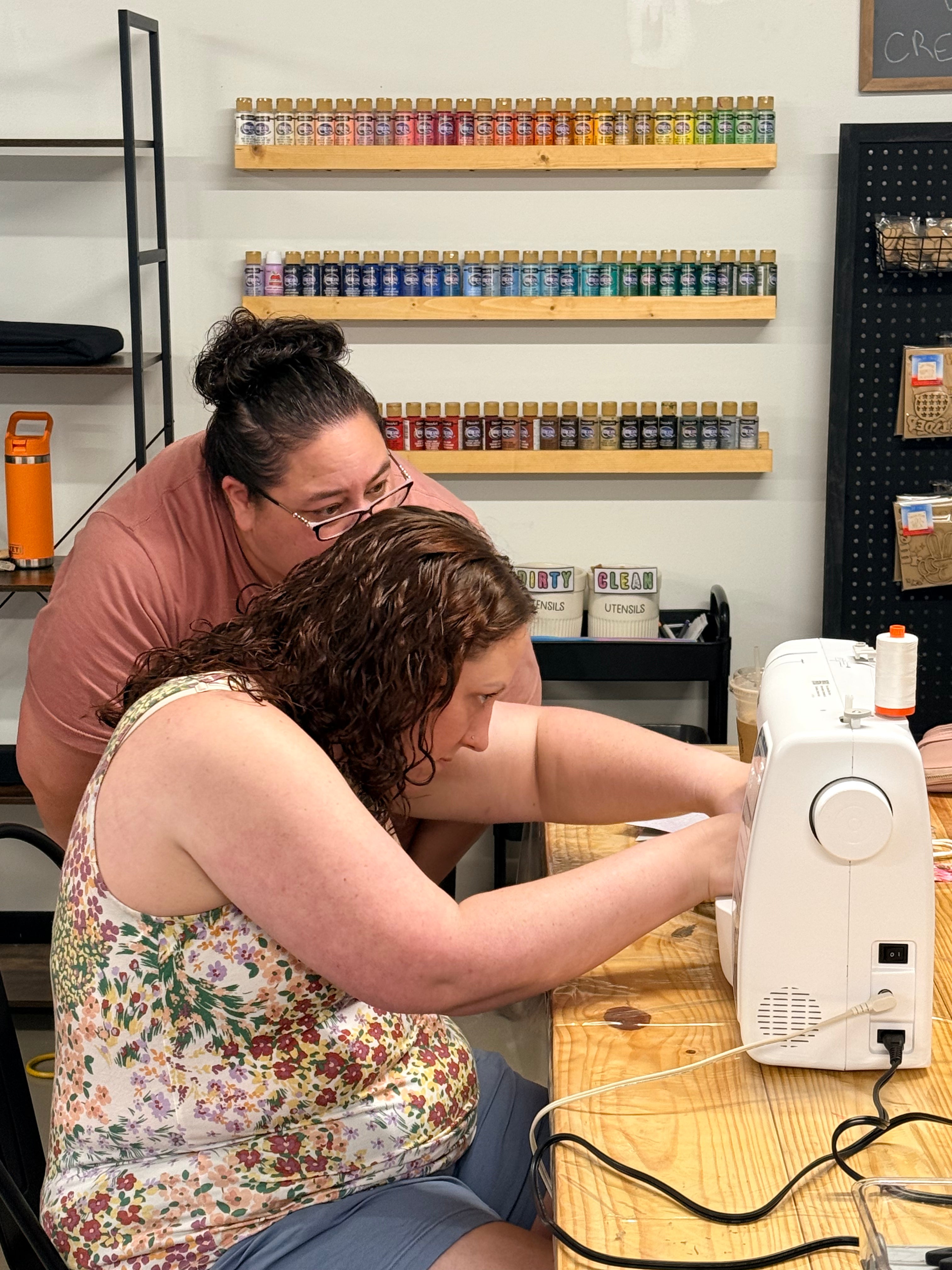 Participant learning to sew with guidance from an instructor during a beginner sewing workshop at Maxilyn House.