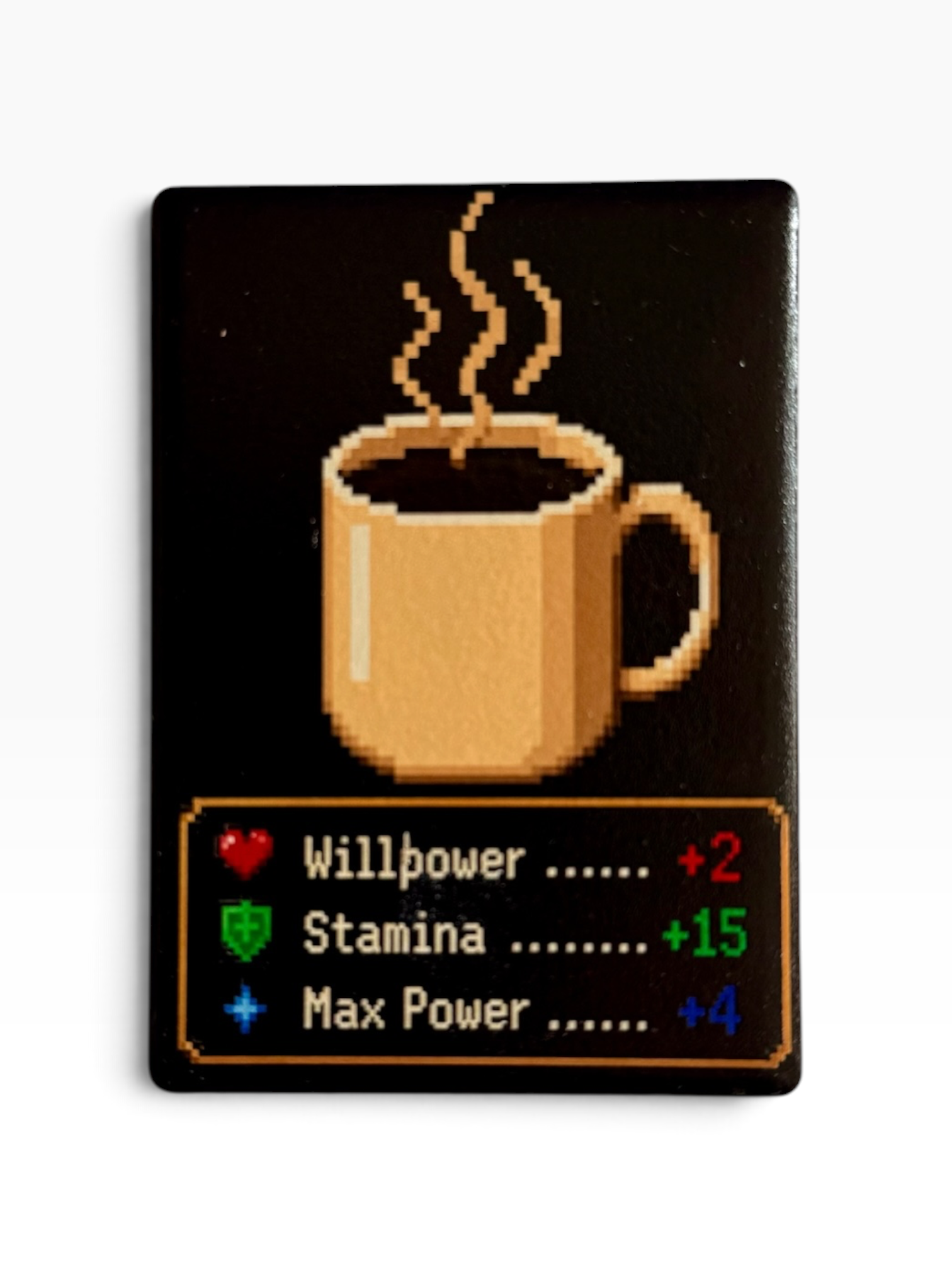 A rectangular black magnet featuring a pixel-art style tan coffee mug with steam and a status-bar style graphic at the bottom reading 'Willpower +2', 'Stamina +15', and 'Max Power +4' in red, green, and blue text.