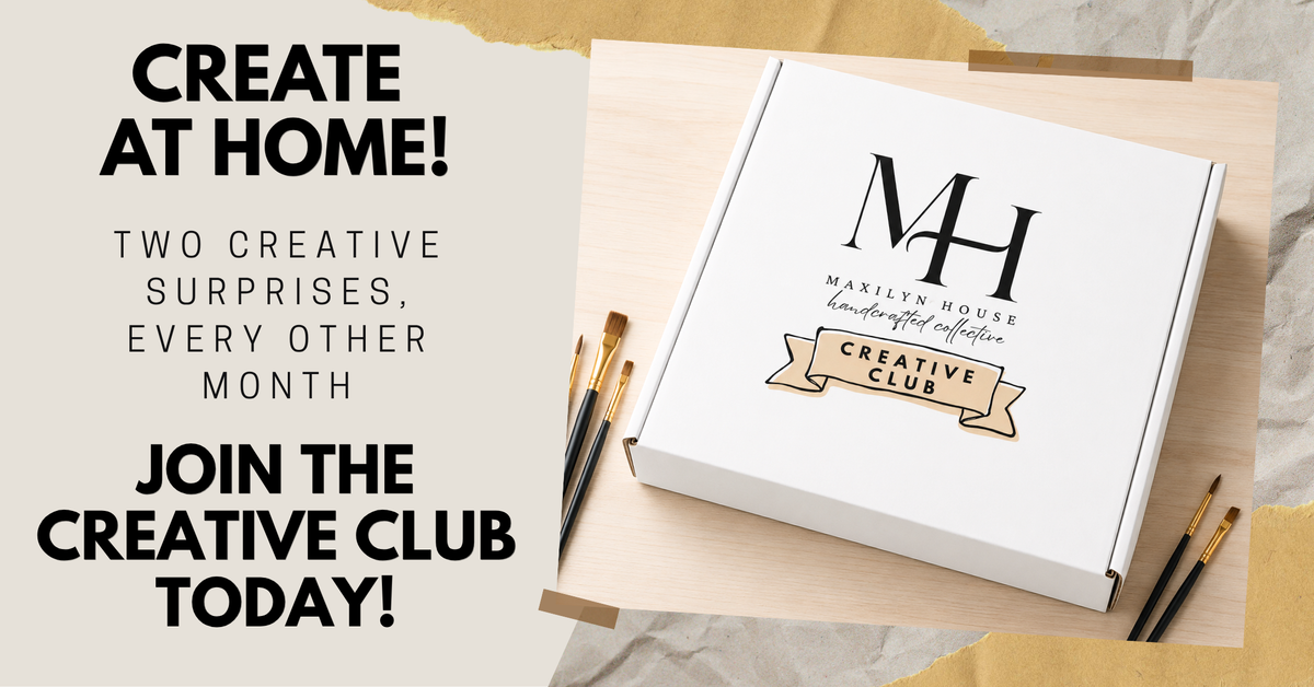 A white branded box labeled 'MH Maxilyn House Handcrafted Collections Creative Club' sits on a light wood board with paintbrushes around it, next to promotional text that reads 'CREATE AT HOME! TWO CREATIVE SURPRISES, EVERY OTHER MONTH. JOIN THE CREATIVE CLUB TODAY!'.