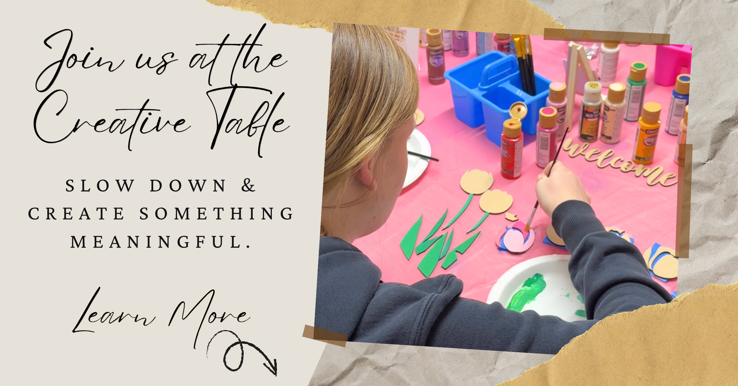 Promotional graphic with torn-paper style borders showing a woman seated at a craft table surrounded by paintbrushes, paint bottles, and colorful supplies. Large text on the left reads, 'Join us at the Creative Table.