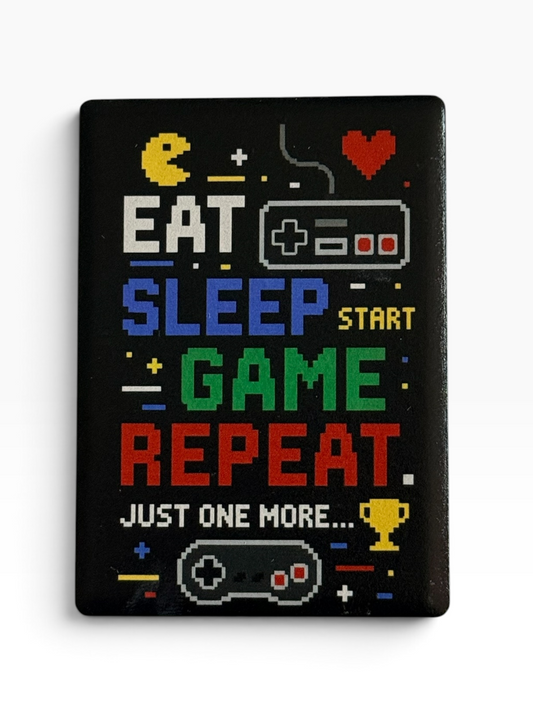 A rectangular ceramic magnet featuring retro 8-bit pixel art text reading 'EAT SLEEP START GAME REPEAT. JUST ONE MORE.