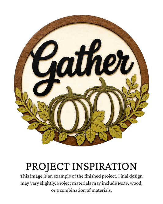Finished project example of a layered round door sign featuring two cream pumpkins surrounded by green and gold autumn foliage with black “Gather” lettering. Text below reads “Project Inspiration.”