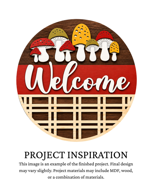 Finished project example of a layered round door sign featuring red, mustard and green mushrooms over a dark wood-style background with “Welcome” lettering. Text below reads “Project Inspiration.”