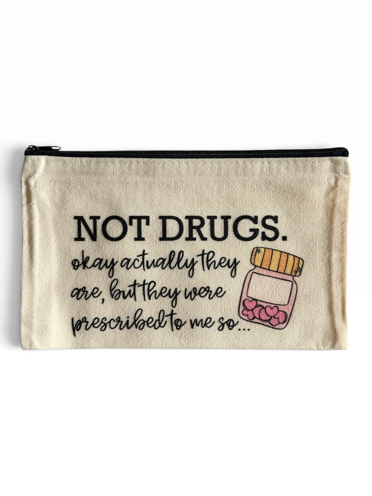 A beige canvas zipper pouch with a black zipper and printed text reading 'NOT DRUGS. okay actually they are, but they were prescribed to me so." and a cute pill bottle clipart .