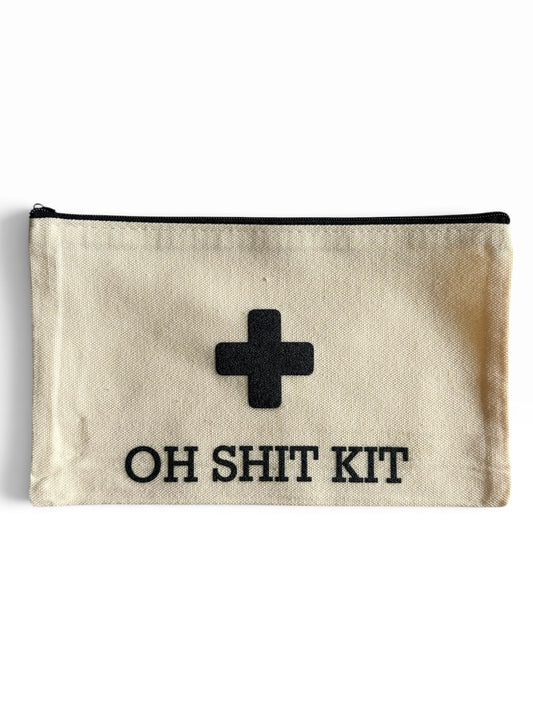 An off-white canvas pouch with a black zipper, featuring a black uv printed medical-style cross and the text 'OH SHIT KIT' in black capital letters.