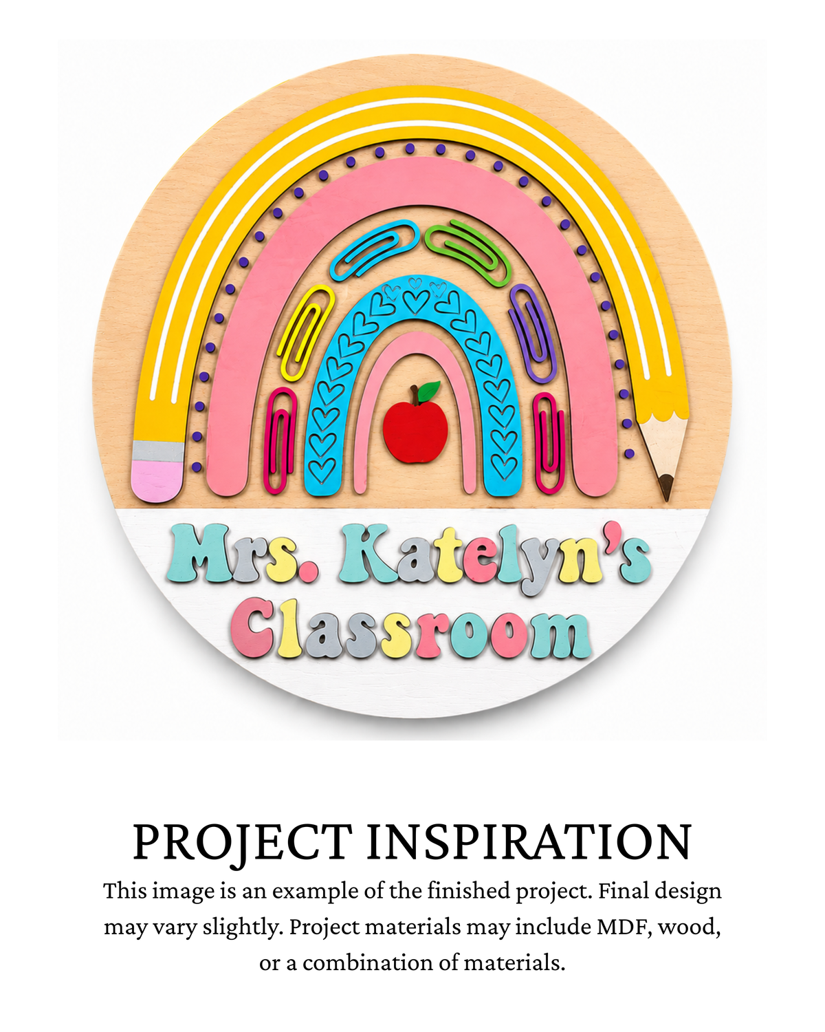Finished project example of a personalized round teacher door sign featuring a colorful school-supply rainbow with pencils, paper clips and an apple, personalized with teacher and classroom name, with text below reading “PROJECT INSPIRATION.”