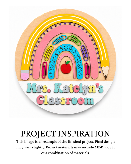 Finished project example of a personalized round teacher door sign featuring a colorful school-supply rainbow with pencils, paper clips and an apple, personalized with teacher and classroom name, with text below reading “PROJECT INSPIRATION.”
