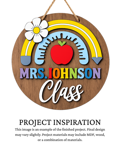 Finished project example of a personalized round teacher door sign featuring a rainbow, apple, daisy and decorative stitching with a teacher name and “Class” lettering. Text below reads “PROJECT INSPIRATION,” describing it as a finished project example.